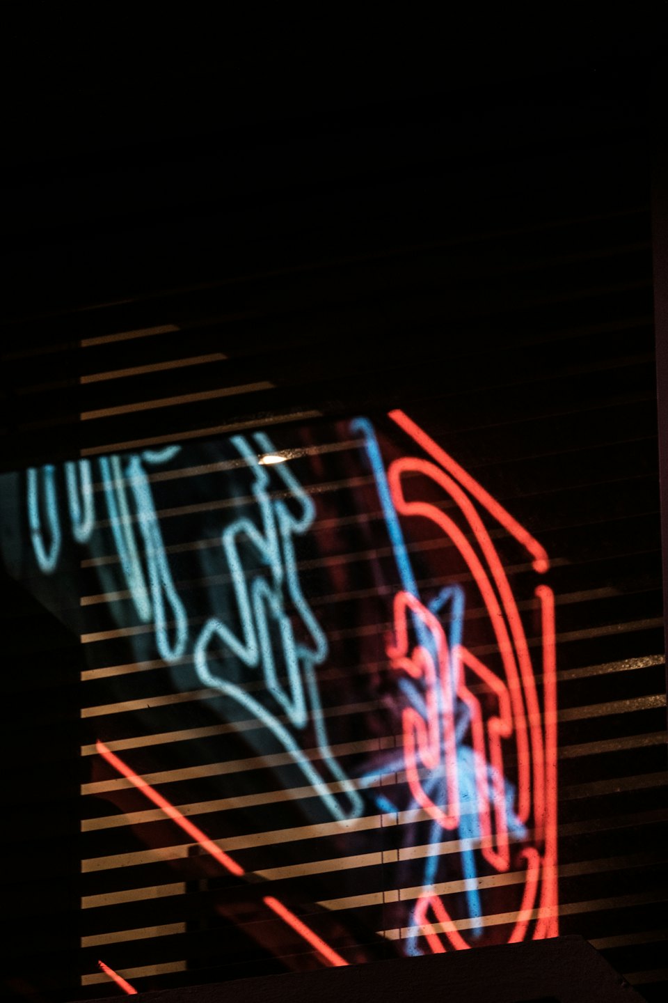 Neon light reflections glowing on a textured dark surface.