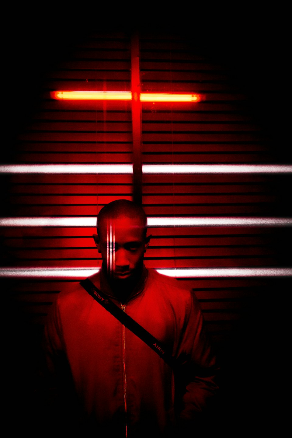 Man in red bomber jacket with diagonal strap.