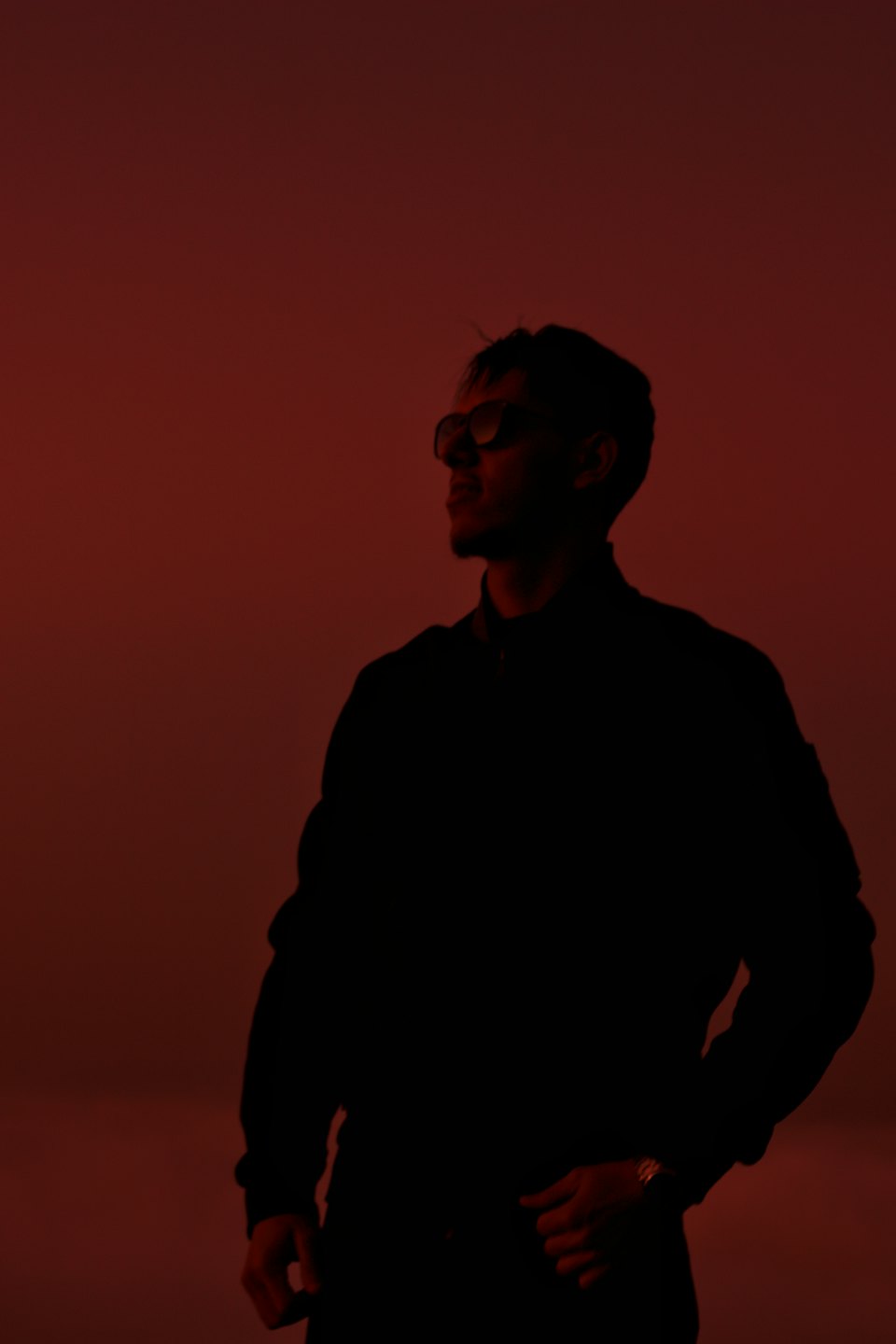 Man in a jacket and sunglasses looking to the left.