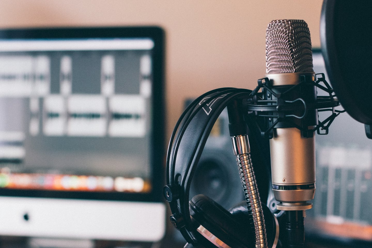 Condenser microphone and headphones on a desk.